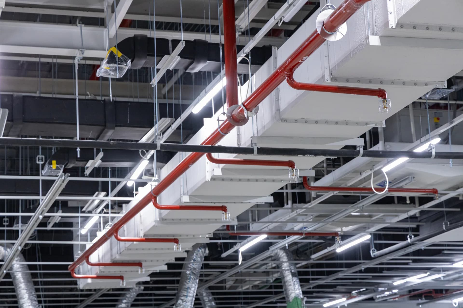Stahltragwerk mit Installationen in einer Industriehalle – Brandschutz-Ausflockung mit mineralischem Spritzputz für grosse Stahlflächen